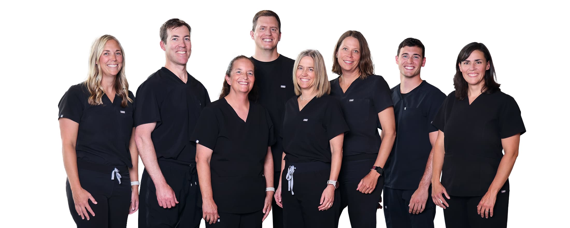 Eight Medeye team members in matching black scrubs stand side by side, smiling in front of a plain white background.